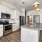 Spacious and well lit kitchen with wood floors and stainless steel appliances